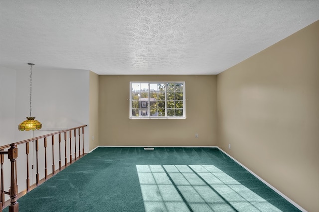 carpeted empty room with a textured ceiling