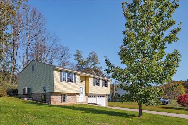 split foyer home with central AC, a garage, and a front lawn