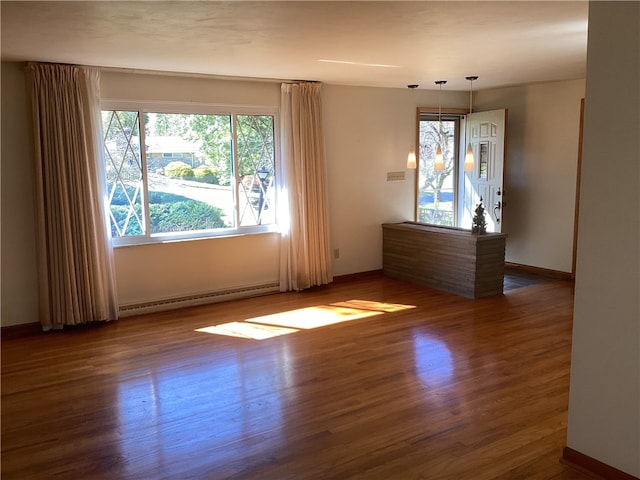 spare room featuring a baseboard radiator and dark hardwood / wood-style flooring