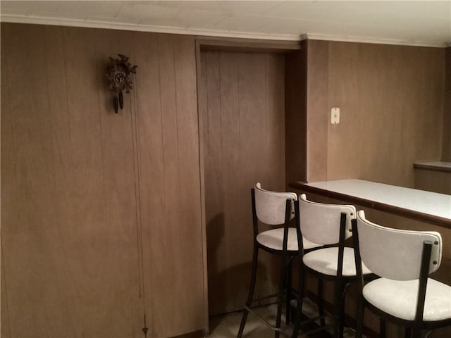 dining room featuring bar and wood walls