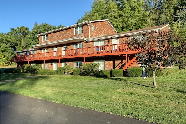 rear view of property with a wooden deck and a lawn