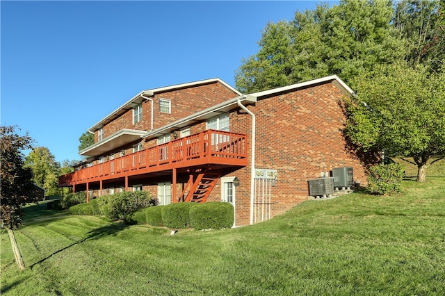 back of house with a yard, a deck, and central air condition unit