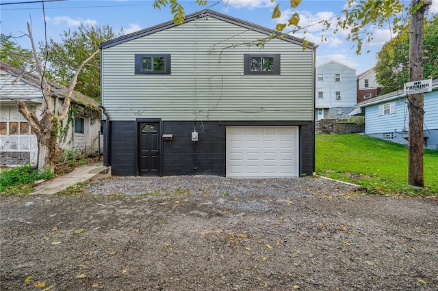 back of house featuring a yard and a garage