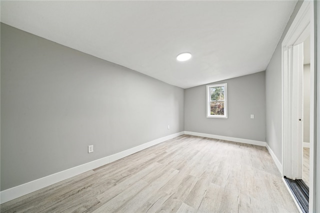 empty room featuring lofted ceiling and light wood-type flooring