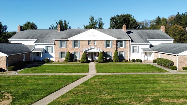 view of front of house with a chimney and a front yard