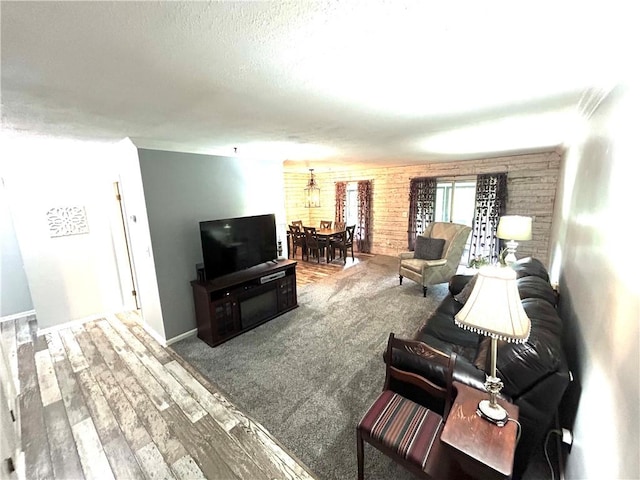 living room with a textured ceiling, wood finished floors, and baseboards