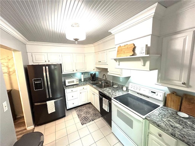 kitchen with dark stone countertops, light tile patterned floors, black appliances, a sink, and crown molding