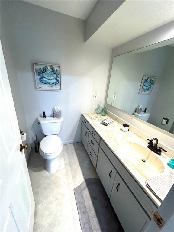 bathroom with double vanity, toilet, and a sink