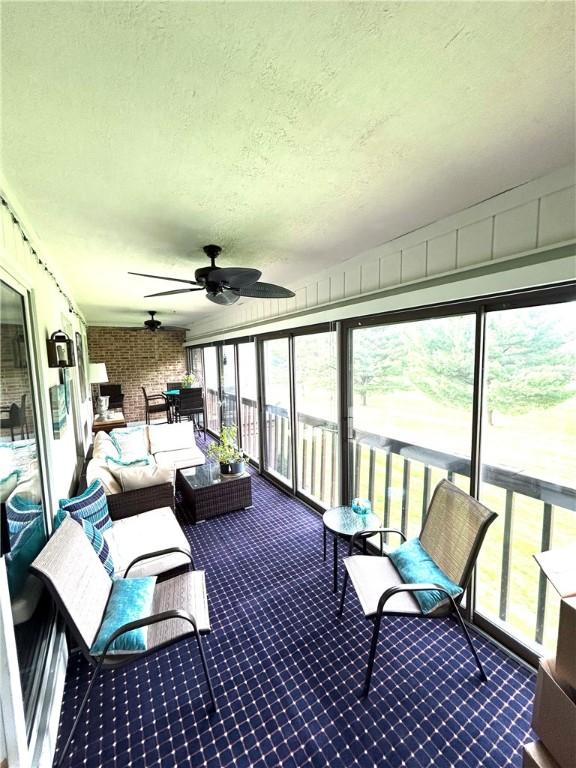 sunroom featuring outdoor lounge area and ceiling fan