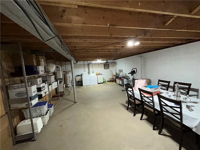 unfinished basement featuring washer and clothes dryer and strapped water heater