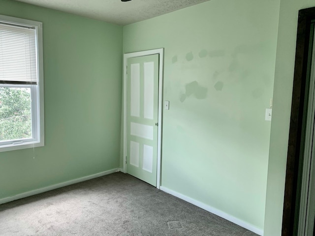 unfurnished room featuring a textured ceiling and carpet floors