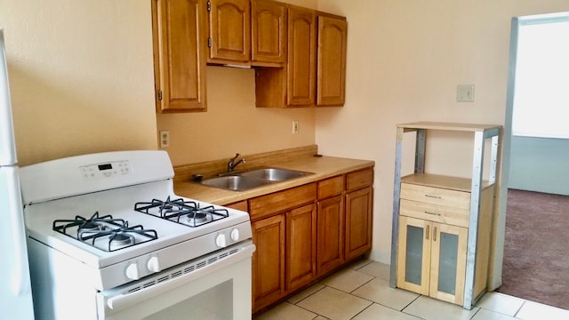 kitchen featuring light colored carpet, sink, and white range with gas stovetop