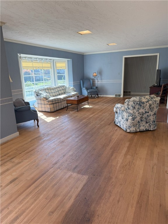 living room with crown molding, hardwood / wood-style flooring, and a textured ceiling