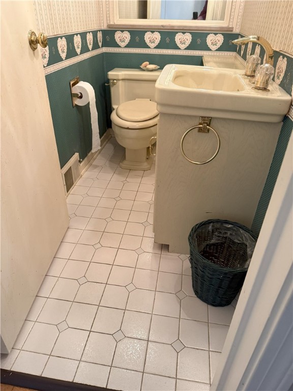 bathroom featuring toilet, tile patterned floors, and sink