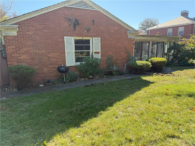 view of property exterior featuring a yard and a sunroom