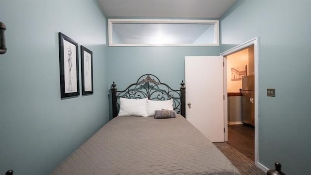 bedroom with stainless steel fridge and carpet flooring