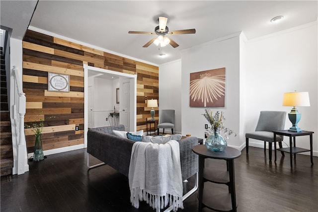 living room featuring wood walls, crown molding, and dark wood-type flooring