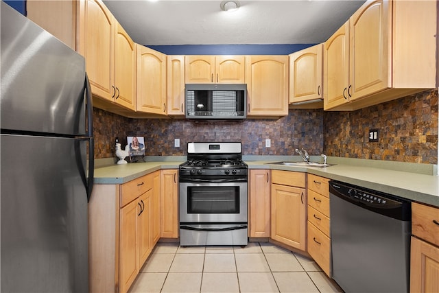 kitchen featuring light brown cabinets, backsplash, sink, light tile patterned floors, and stainless steel appliances