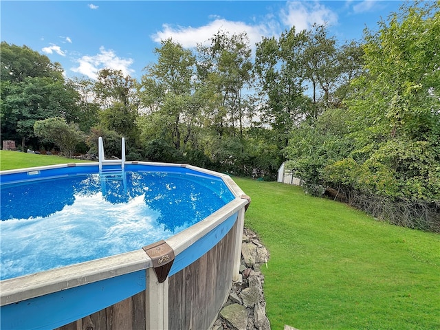 view of swimming pool with a lawn