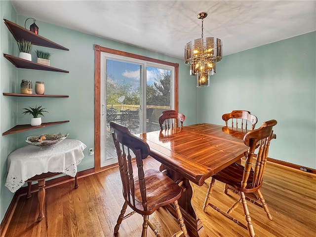 dining area featuring an inviting chandelier and light hardwood / wood-style flooring