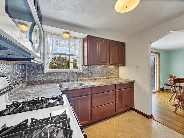 kitchen featuring light tile patterned floors, sink, and backsplash