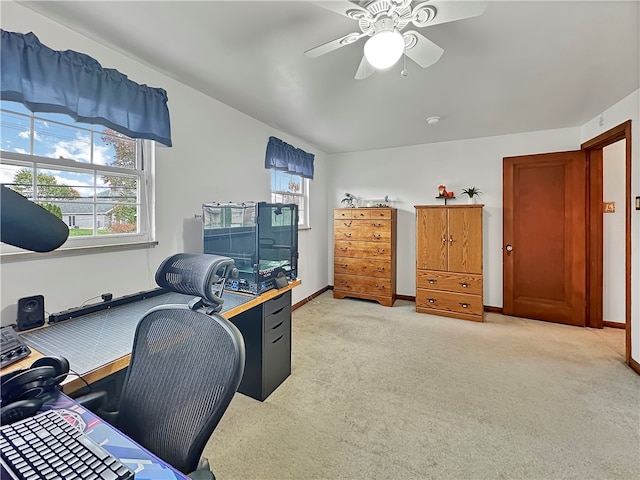 carpeted home office featuring ceiling fan