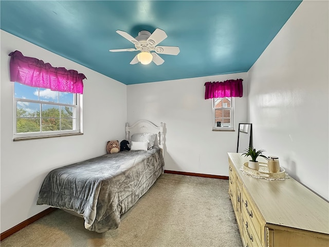 bedroom featuring ceiling fan, light carpet, and multiple windows