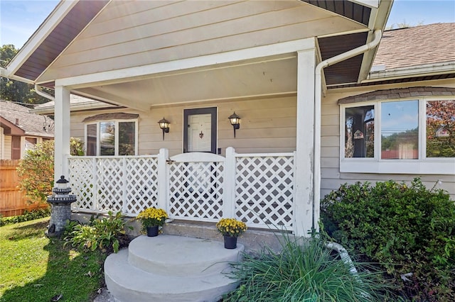 view of exterior entry featuring covered porch