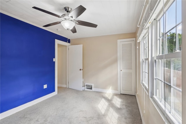 unfurnished room featuring light colored carpet and ceiling fan