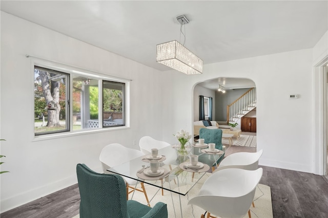 dining room featuring dark hardwood / wood-style floors and ceiling fan with notable chandelier