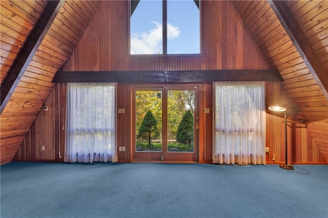 interior space with high vaulted ceiling, carpet floors, and wooden walls