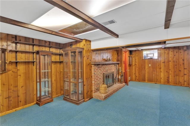 basement with wooden walls, carpet floors, and a brick fireplace