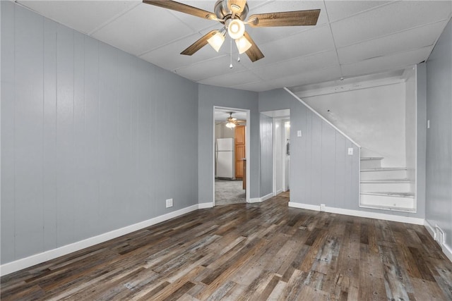 unfurnished room with dark hardwood / wood-style flooring and wooden walls