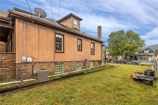 view of home's exterior featuring central air condition unit, a yard, and cooling unit