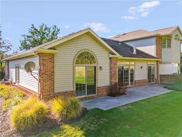 rear view of house with a patio area and a lawn