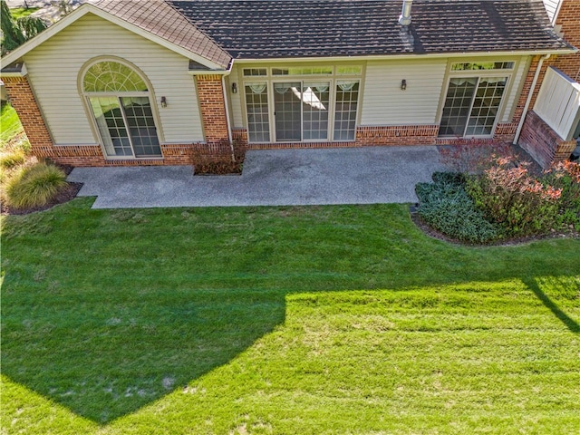 rear view of house featuring a patio and a lawn