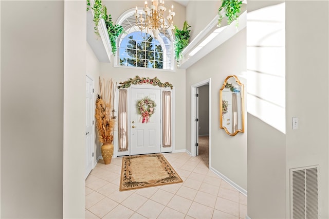 entryway with light tile patterned floors, a notable chandelier, and a high ceiling