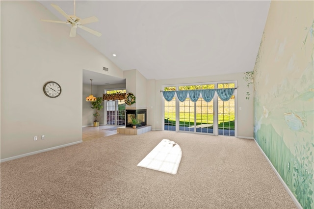 unfurnished living room with a tile fireplace, light colored carpet, high vaulted ceiling, and ceiling fan