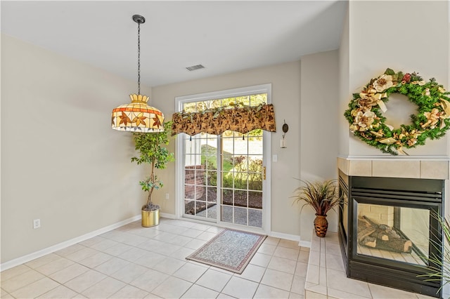 doorway to outside featuring a fireplace and light tile patterned floors