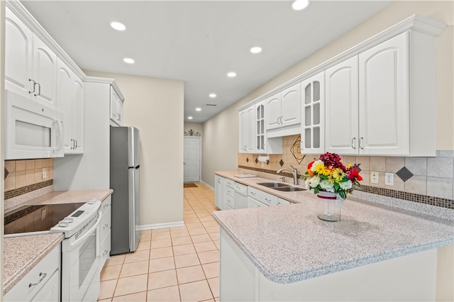 kitchen with sink, light tile patterned floors, white cabinetry, white appliances, and tasteful backsplash