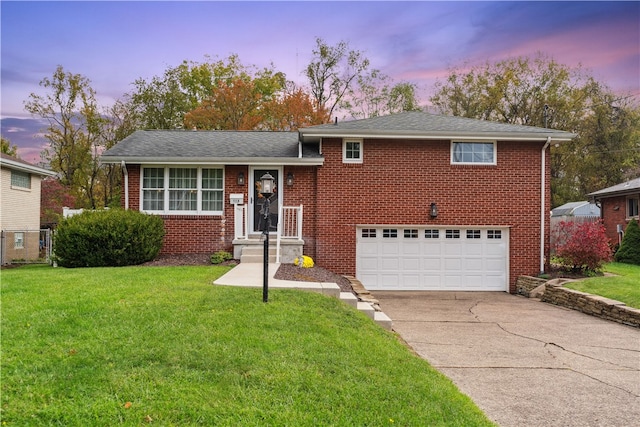 tri-level home featuring a yard and a garage