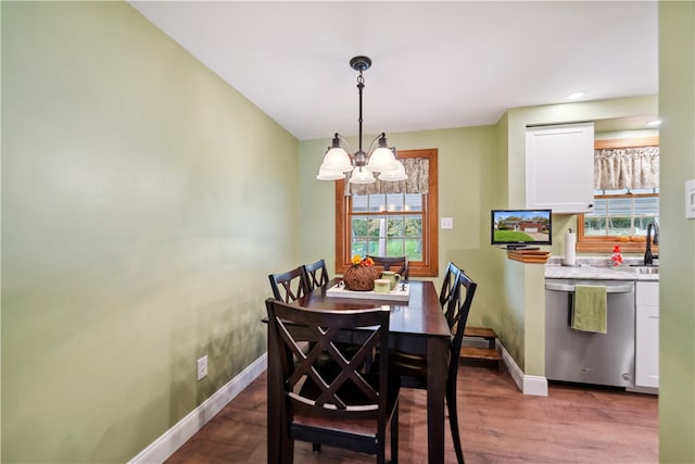 dining room with sink, a chandelier, and light hardwood / wood-style floors