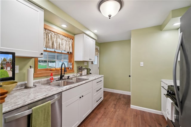 kitchen with light hardwood / wood-style flooring, white cabinets, sink, and stainless steel appliances