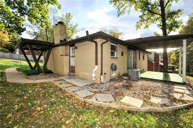 view of property exterior featuring central air condition unit, a patio area, and a lawn