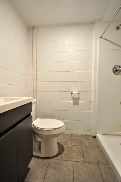 bathroom featuring vanity, toilet, and a shower