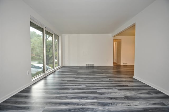 empty room with dark hardwood / wood-style flooring