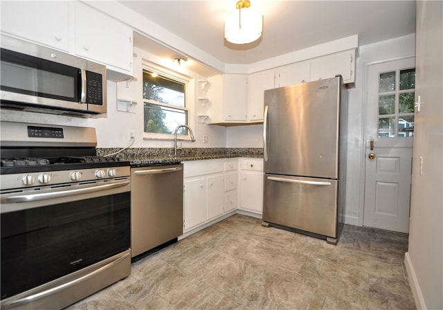 kitchen with sink, appliances with stainless steel finishes, dark stone counters, and white cabinets