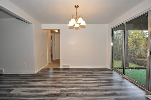 unfurnished dining area featuring dark hardwood / wood-style flooring, a notable chandelier, and a wealth of natural light