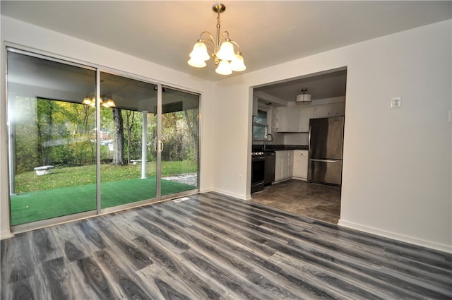 unfurnished dining area featuring sink, dark hardwood / wood-style flooring, and a chandelier