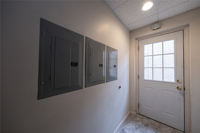 doorway to outside with electric panel and a drop ceiling